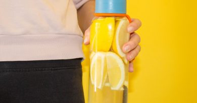 cropped-photo-of-woman-holding-glass-water-bottle-with-lemons-inside-against-yellow-background