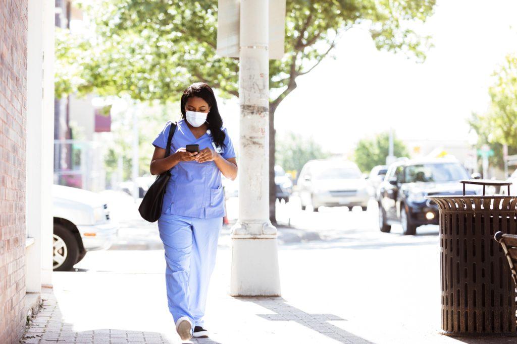 A healthcare professional walking to the hospital in her sketchers sneakers