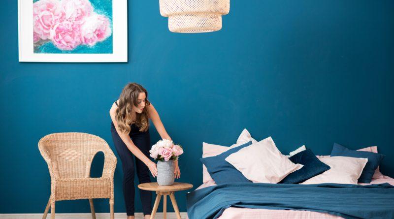 a woman adding a signature touch to her bedroom with flowers.