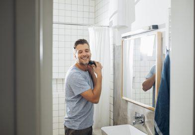 Man at home shaving his facial hair using the Philips Norelco Multigroomer Series 3000.