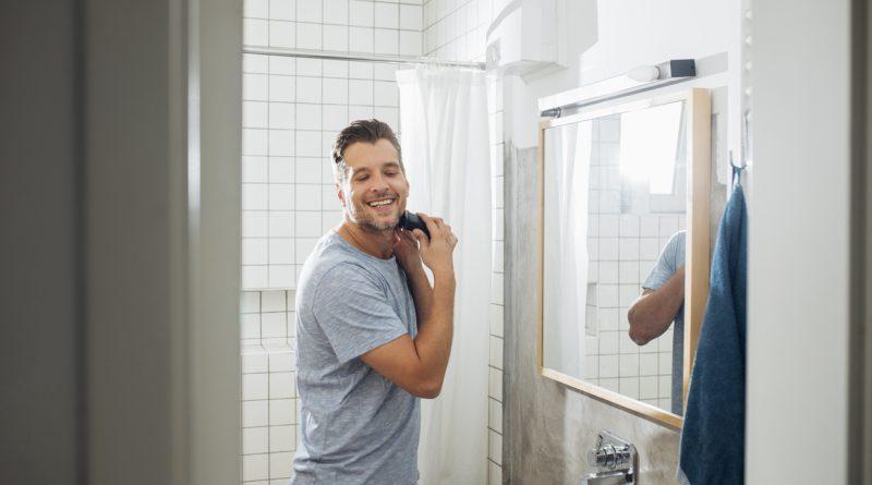 Man at home shaving his facial hair using the Philips Norelco Multigroomer Series 3000.