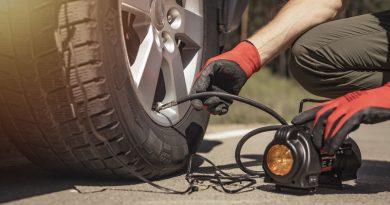 Man inflating his car tire using the AstroAI Air Compressor Tire Inflator.