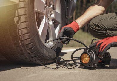 Man inflating his car tire using the AstroAI Air Compressor Tire Inflator.