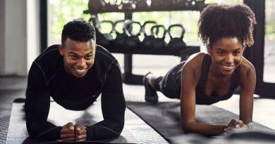 Couple at home working out and performing planks - using Plankpad PRO to help them with their exercises.
