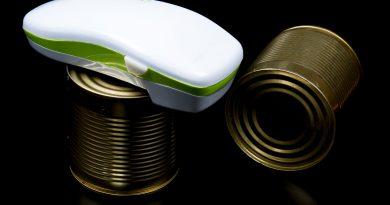 An electric can opener on top of a canned good.