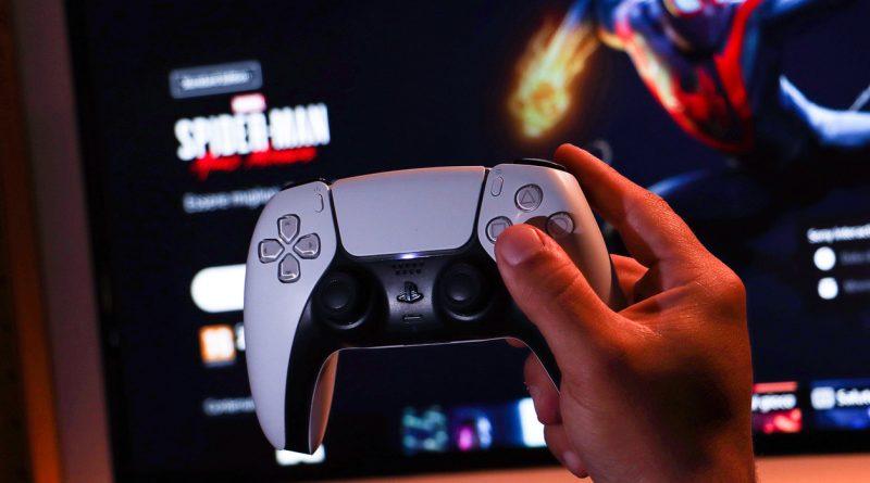 Man holding a controller of a Sony PlayStation 5 Digital Edition - with a digital game shown in the background.