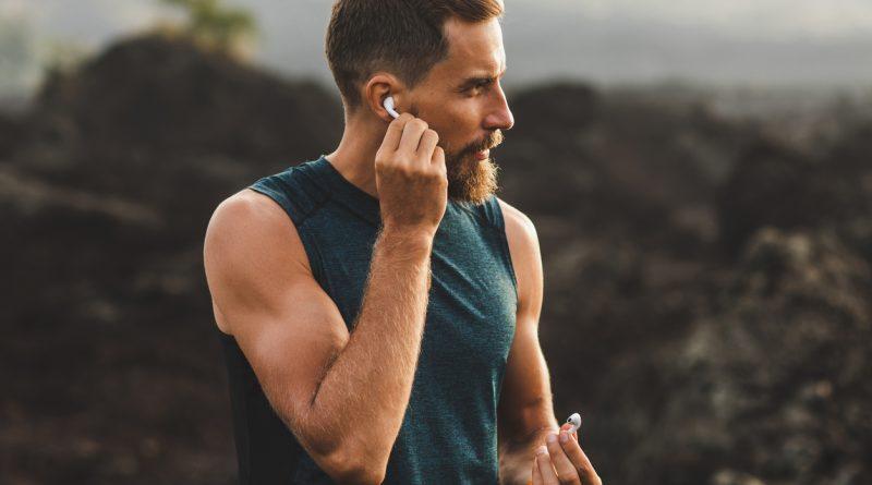 Man working out while listening to his favorite music through his wireless earbuds.