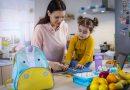 Lunch boxes for kids | Mother and daughter packing lunch in their home kitchen.