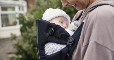 Unique gifts for new moms - mother carrying her baby using a newborn carrier.