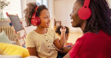 Mother and child wearing wireless headphones while playing - headphones for kids.