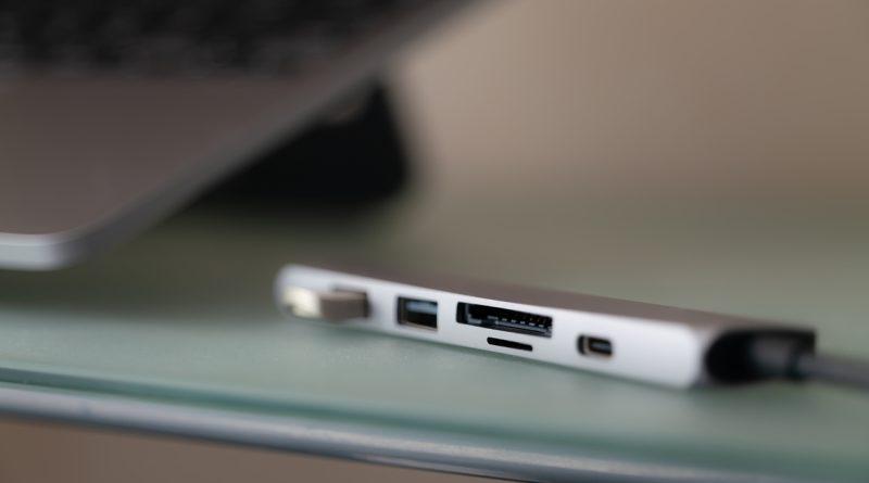 A multi-purpose USB hub adapter connected to a laptop device.